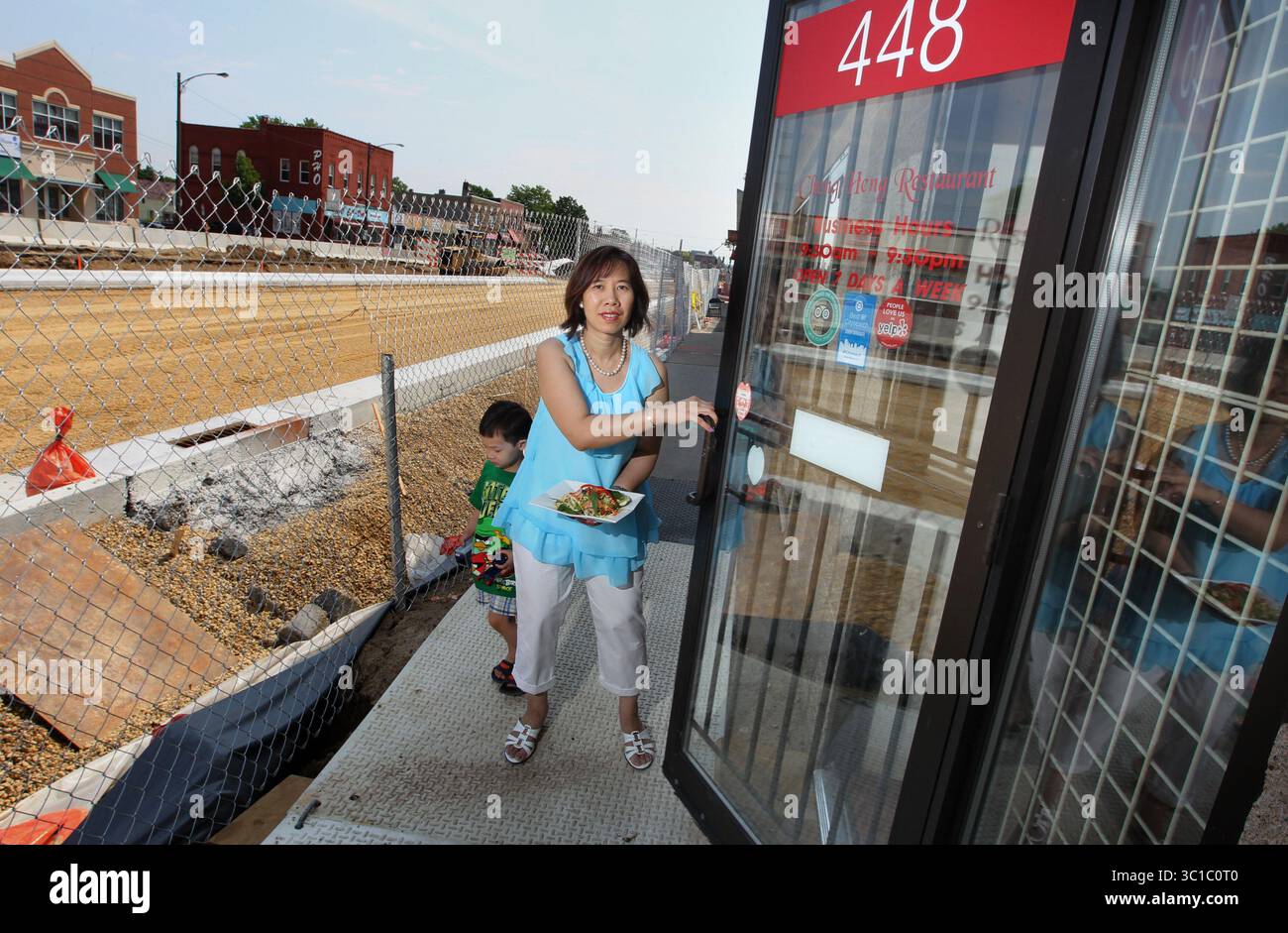 June 7, 2012 - Minneapolis, U.S. - A battle of wills have Kunrath and construction workers at odds. Business has slowed to almost a stop at the great little restaurant. Kunrath with her 3 year-old son Ivan go throught the front doot after a photo on the street at the Cheng Heng, 448 University Av. W., 651-222-5577 (between Mackubin and Arundel, south side): Owners Kunrath and Kevin Lam.  A dining guide for University Avenue restaurants/markets being buried under light rail construction, from approximately Victoria St. on the west to Farrington St. on the east.[   Assignments #20023887A  June 7 Stock Photo