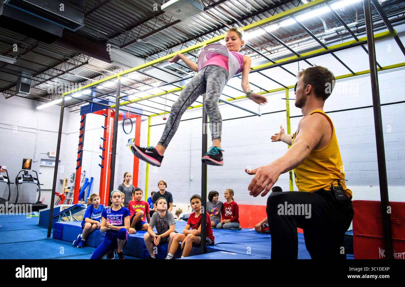 November 21, 2017 - Edina, Minnesota, USA - Addie Muckenhirn took a leap, testing on the the Lache dismount. Tuesday, November 21, 2017 ..If you want your kid to drop the video game controller and get off the couch, you can take your pick of gyms and clubs and teams in the Twin Cities in sports ranging from fencing to figure skating to rowing...Add being a ninja warrior...In the last two or three years, at least six gyms have sprung up in the metro area offering to train people to be ninja warriors just like on the obstacle course contest NBC television show, ''American Ninja Warriors.'' At le Stock Photo