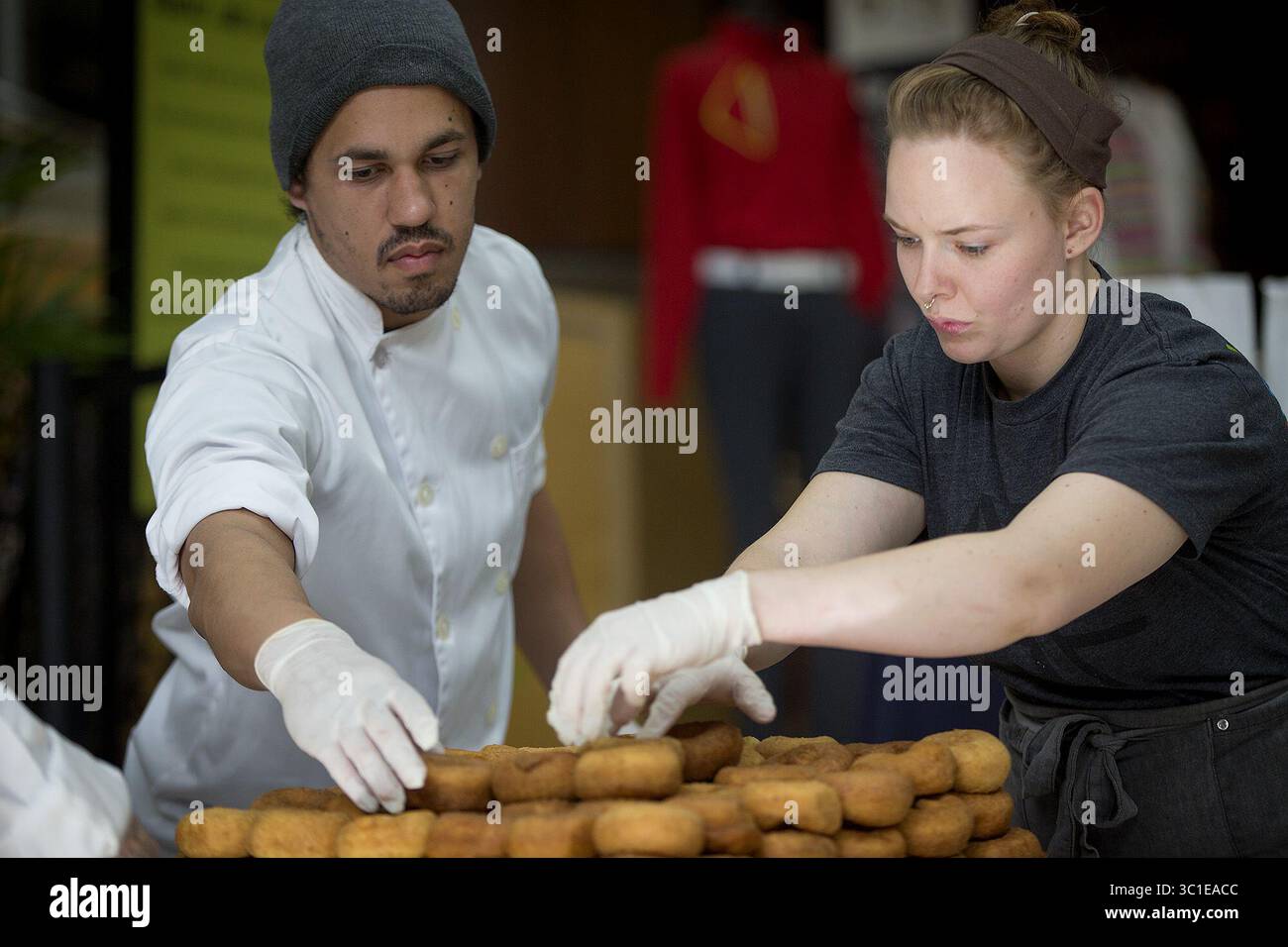 October 17, 2017 - Bloomington, MN, USA - United States - Bakers Armand Osbon, cq, left, and Dana Stowell, carefully stacked donuts as they joined local award-winning baker Katherine Gerdes and other bakers attempt at breaking a world record for the highest doughnut stack at the Minneapolis/St. Paul International Airport, Tuesday, October 17, 2017 in Bloomington, MN. (Credit Image: Elizabeth Flores/Minneapolis Star Tribune/TNS via ZUMA Wire) Stock Photo