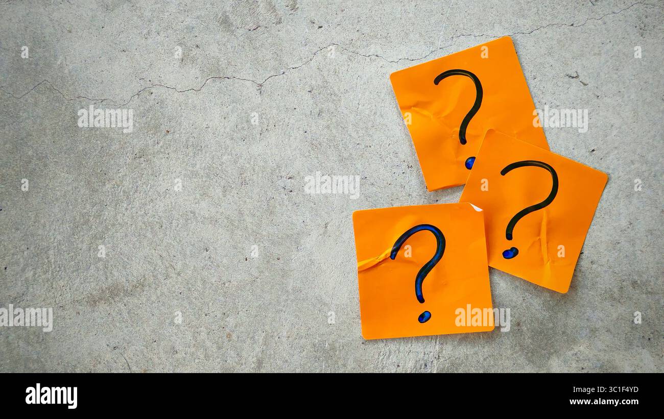 Three Blue Question Marks on Orange Sticky Notes on a Cracked Concrete Background Stock Photo