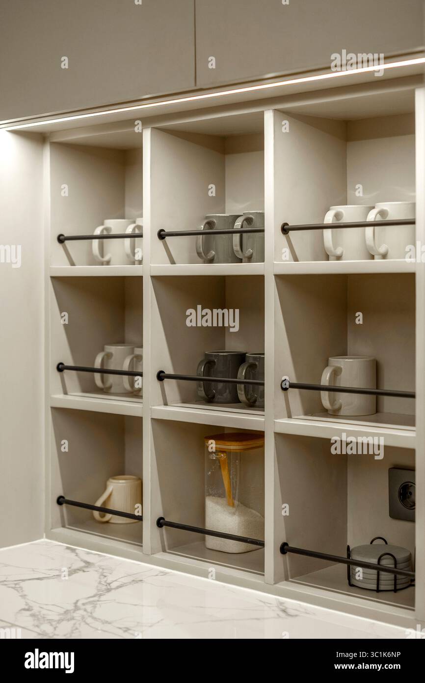 View of Modern pantry shelves with neatly organized white and grey coffee mugs ...