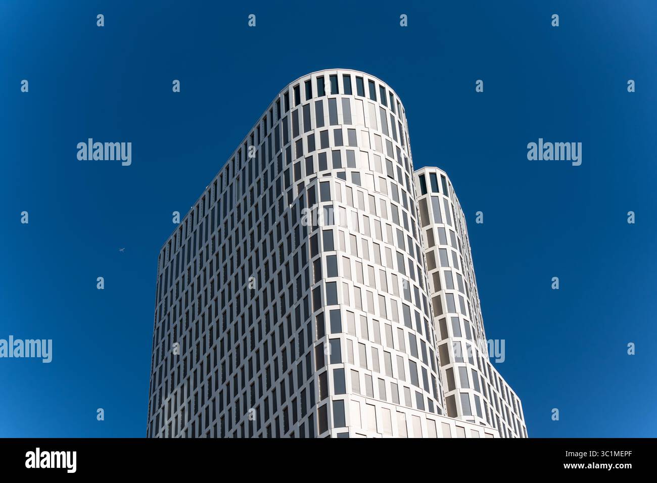 Zoofenster Building. The iconic white facade of the Upper West Berlin building gleams in sunlight, set against a vivid blue sky. Its modern, rounded d Stock Photo