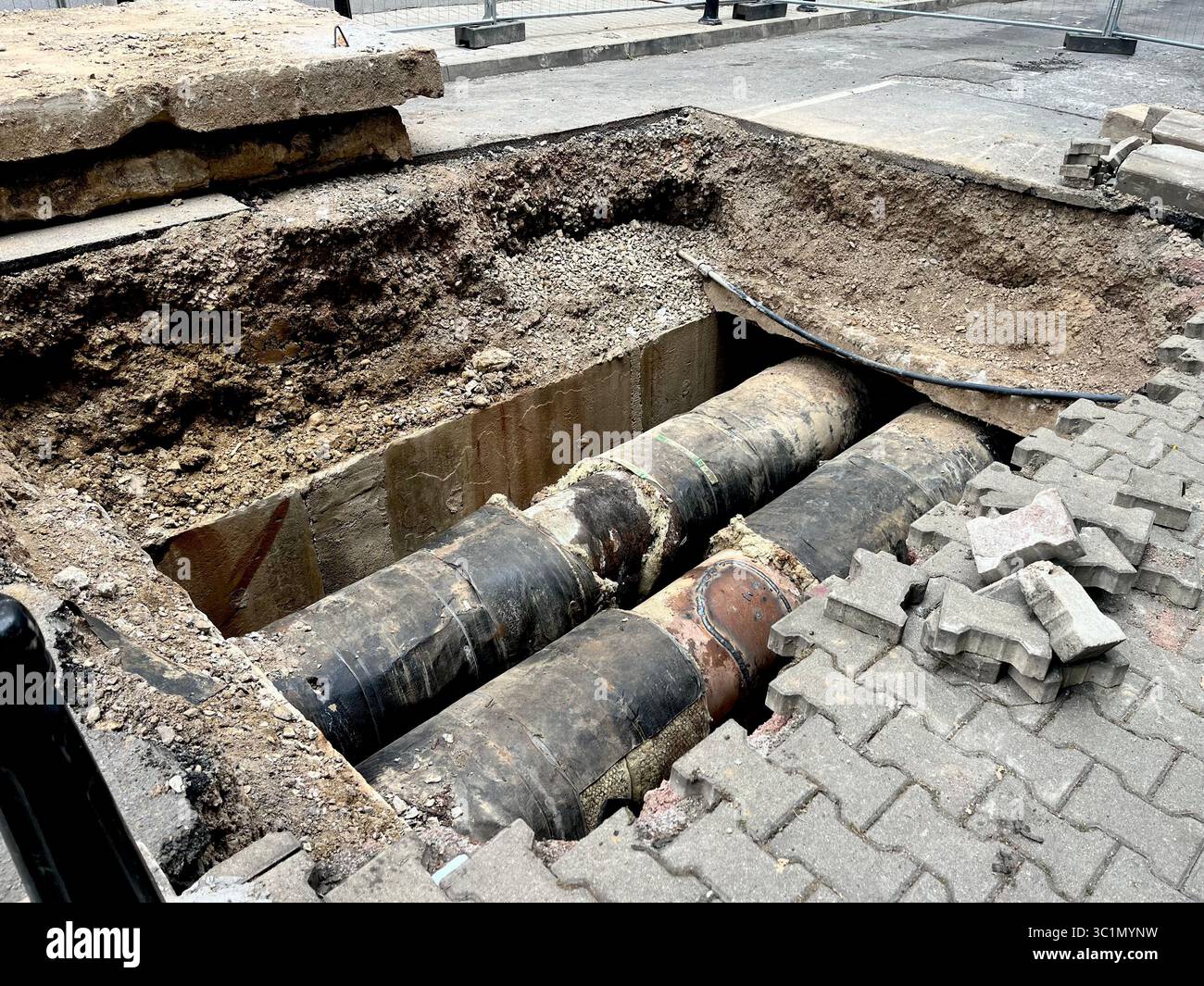 Urban infrastructure and pipeline replacement street works and cross section of city road digging as underground water mains pipework, Sofia Bulgaria - Smartphone Captured Stock Image