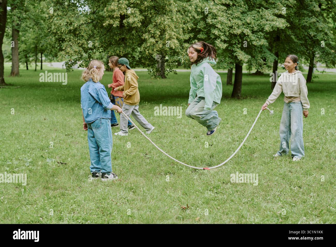 Group of Diverse Children Playing Jump Rope in Park Stock Photo - Alamy
