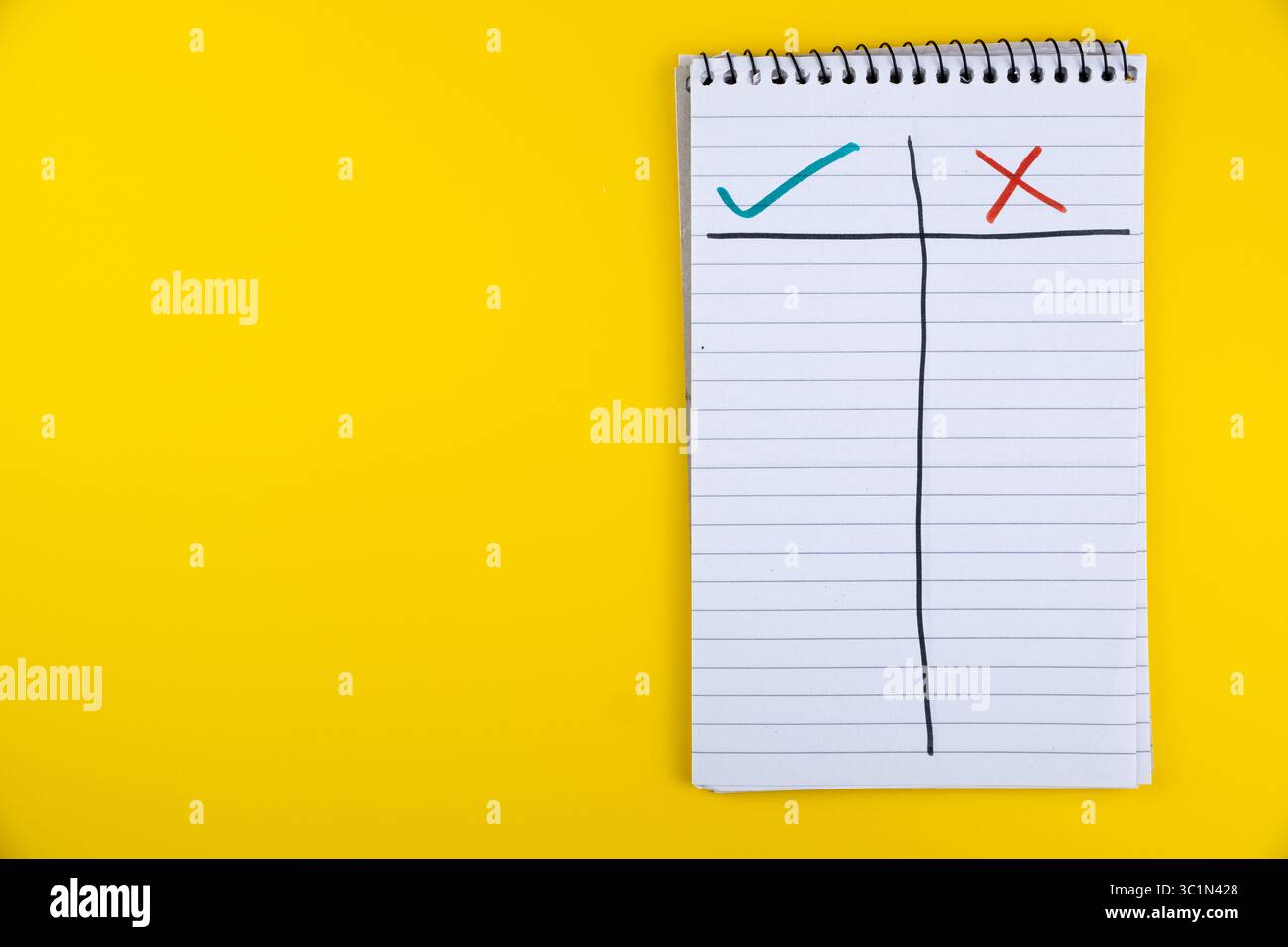 Notebook with checklist marked with check and cross on bright yellow ...
