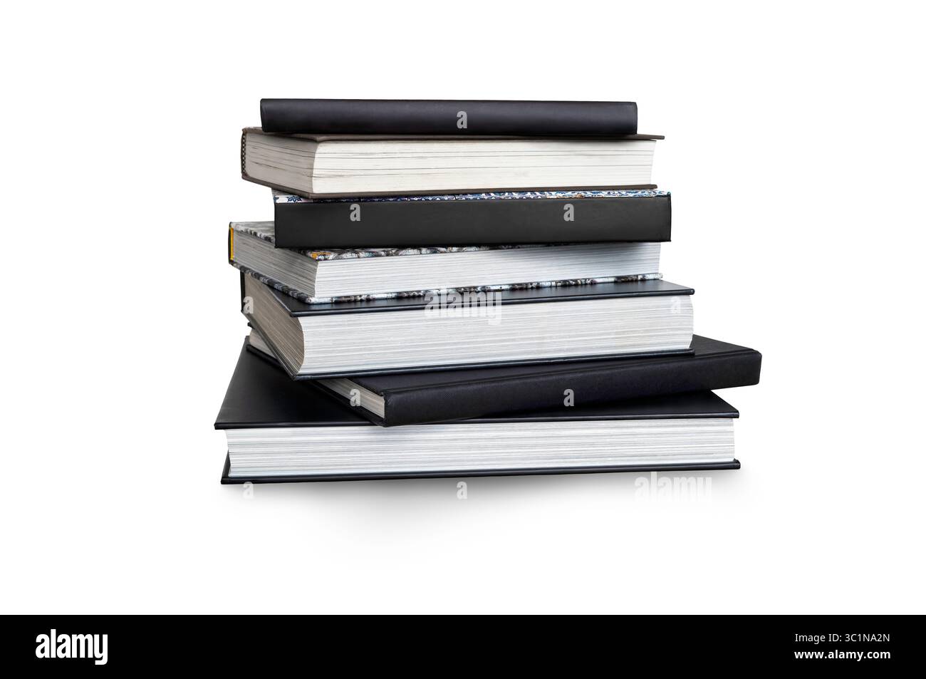 A front side on view of a pile of seven study books, textbooks, on a table isolated against a white background Stock Photo