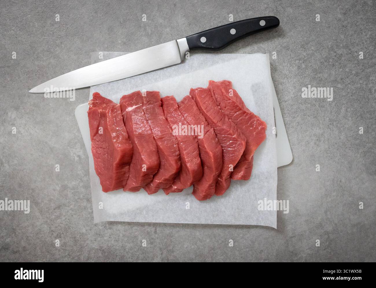 fresh raw sliced beef meat on cutting board, top view Stock Photo
