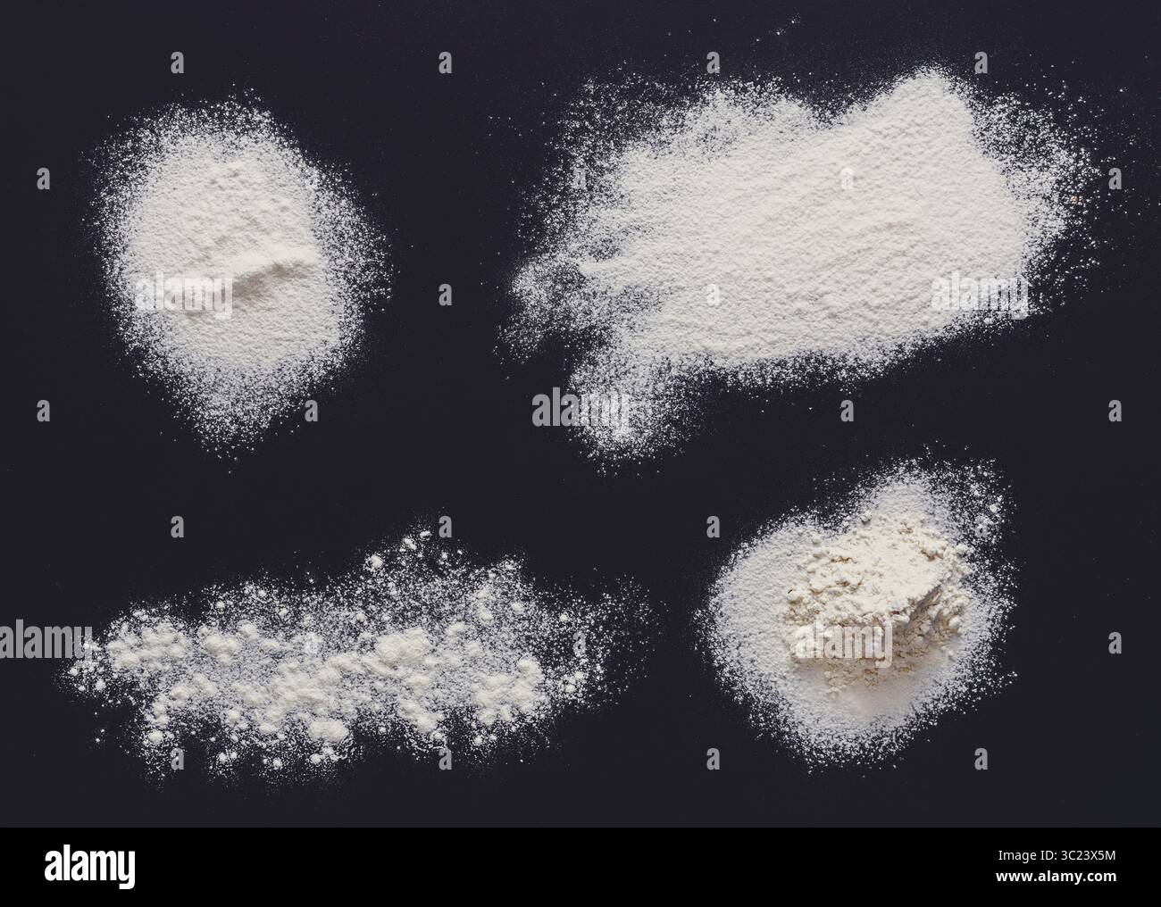 Sprinkled wheat flour splash spots on black background Stock Photo
