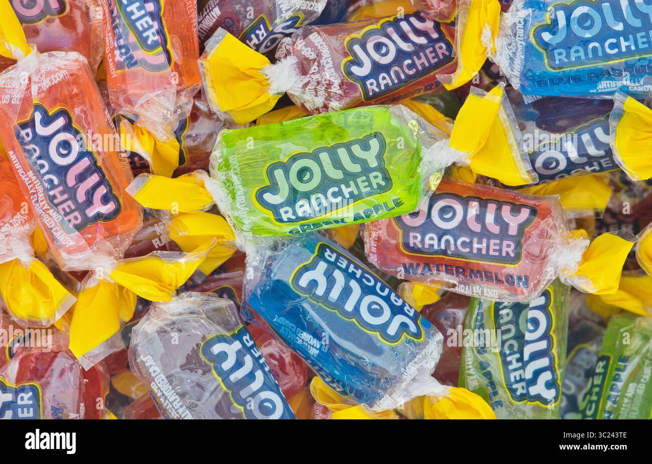 Houston, Texas USA 07-20-2025: Jolly Rancher hard candy in wrappers assorted flavors scattered. Stock Photo