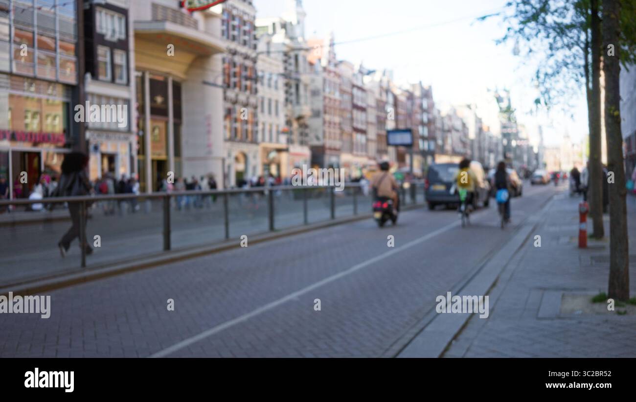 Defocused city scene with blurred figures and bicycles along a bustling ...