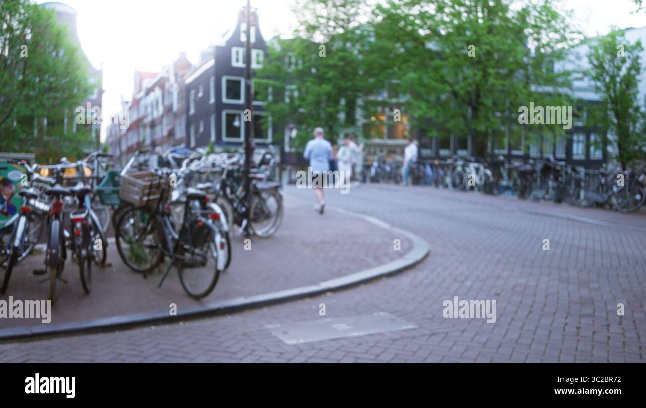 Blurred scene in amsterdam with bicycles, cobblestone streets, and ...