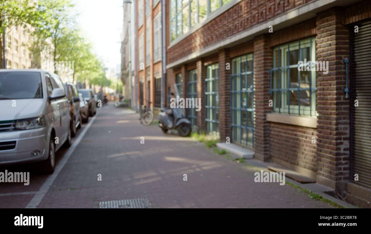 Blurred city street in amsterdam with defocused buildings, vehicles ...