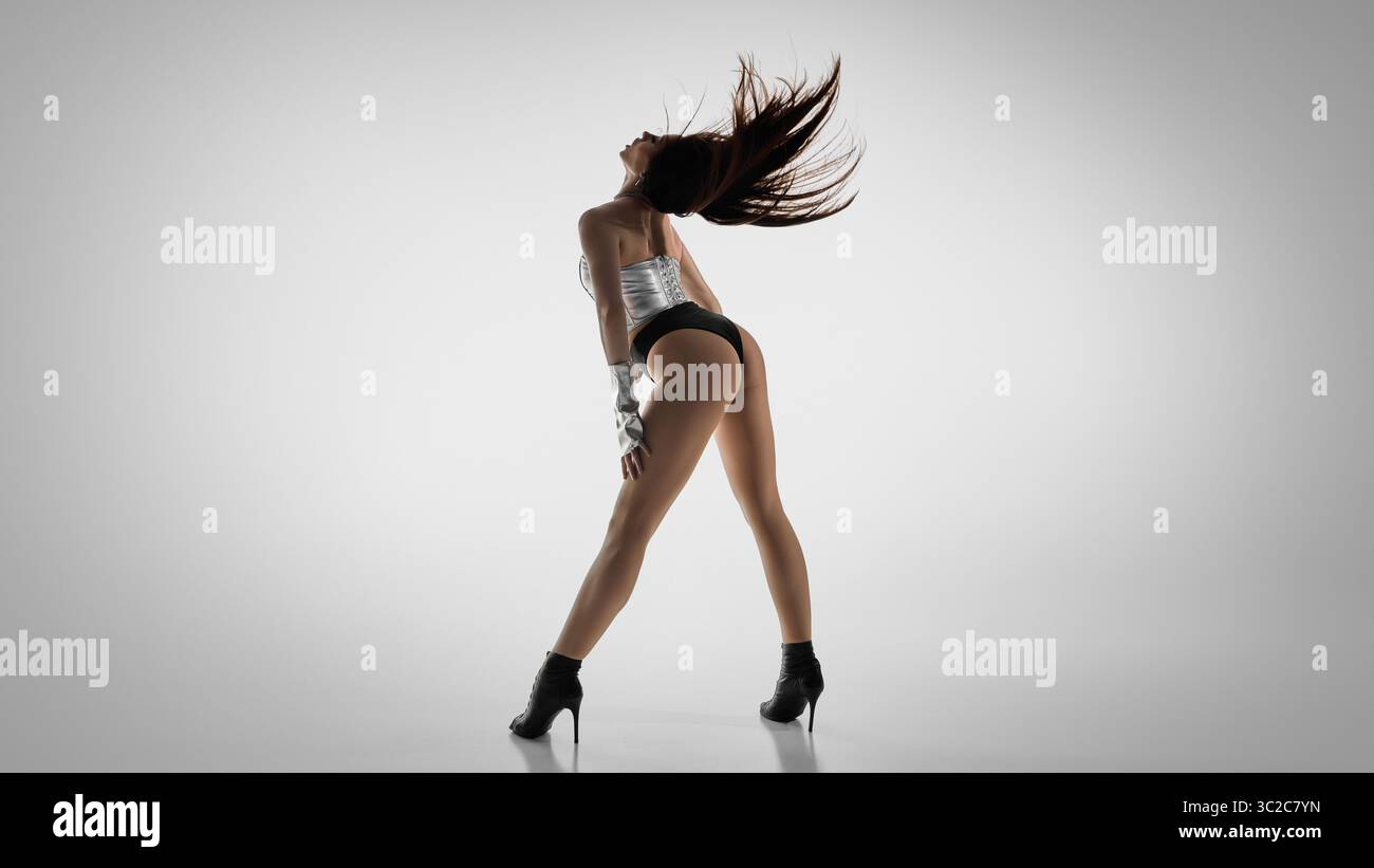 Energetic dancer in high heels strikes a dynamic jazz funk pose Stock Photo