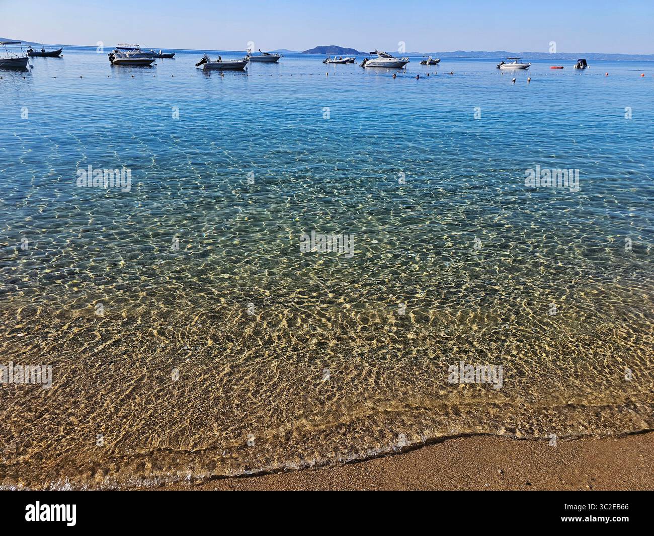 Idyllic seaside view with boats on clear blue water in Mediterranean sea, Greece - Smartphone Captured Stock Image