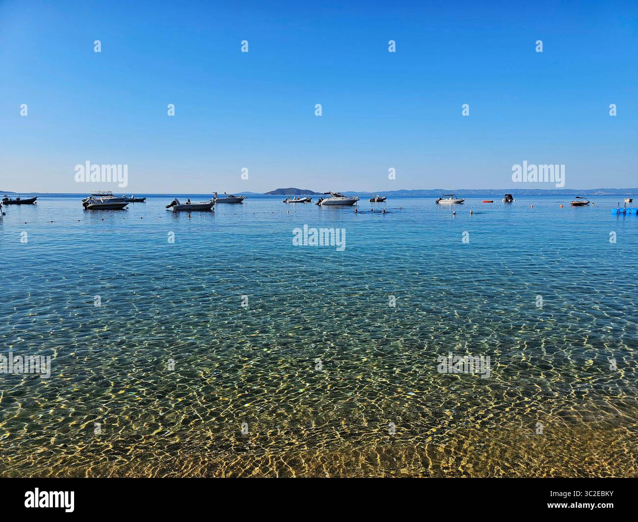 Idyllic seaside view with boats on clear blue water in Mediterranean sea, Greece - Smartphone Captured Stock Image