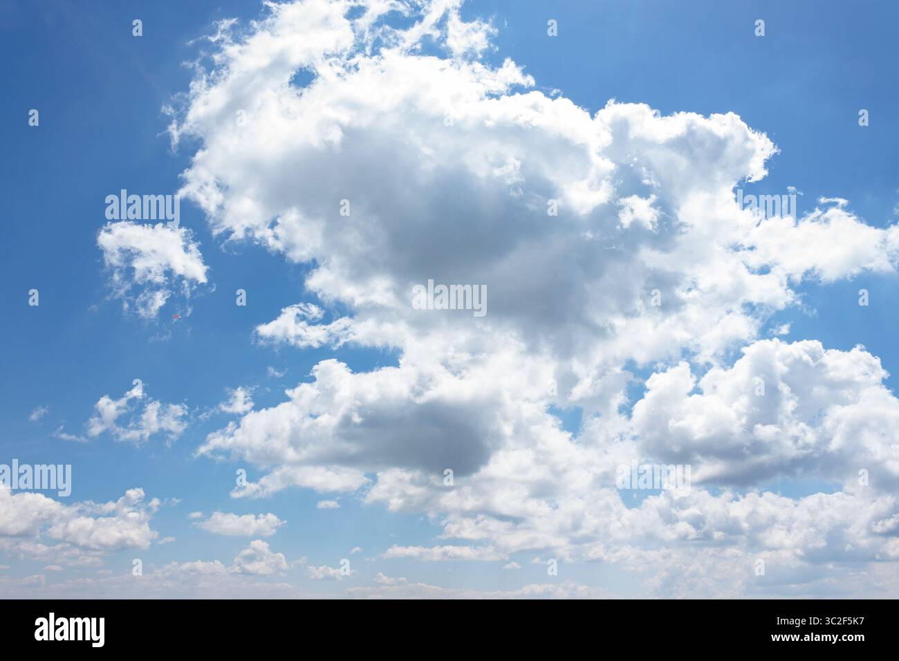 white fluffy clouds on the azure blue sky. cumulus cloudscape in bright light in summer. weather background for vacation on a sunny day. cloudy atmosp Stock Photo