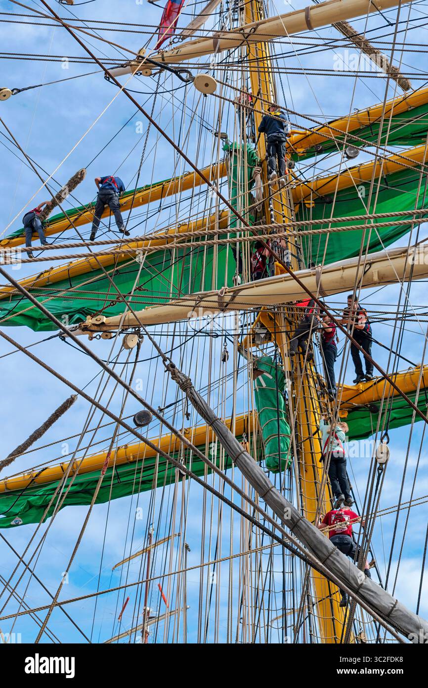 Tall Ships Aberdeen Harbour Scotland July 2025 sailors working on the masts and green sails of ship Alexander Von Humboldt II Stock Photo