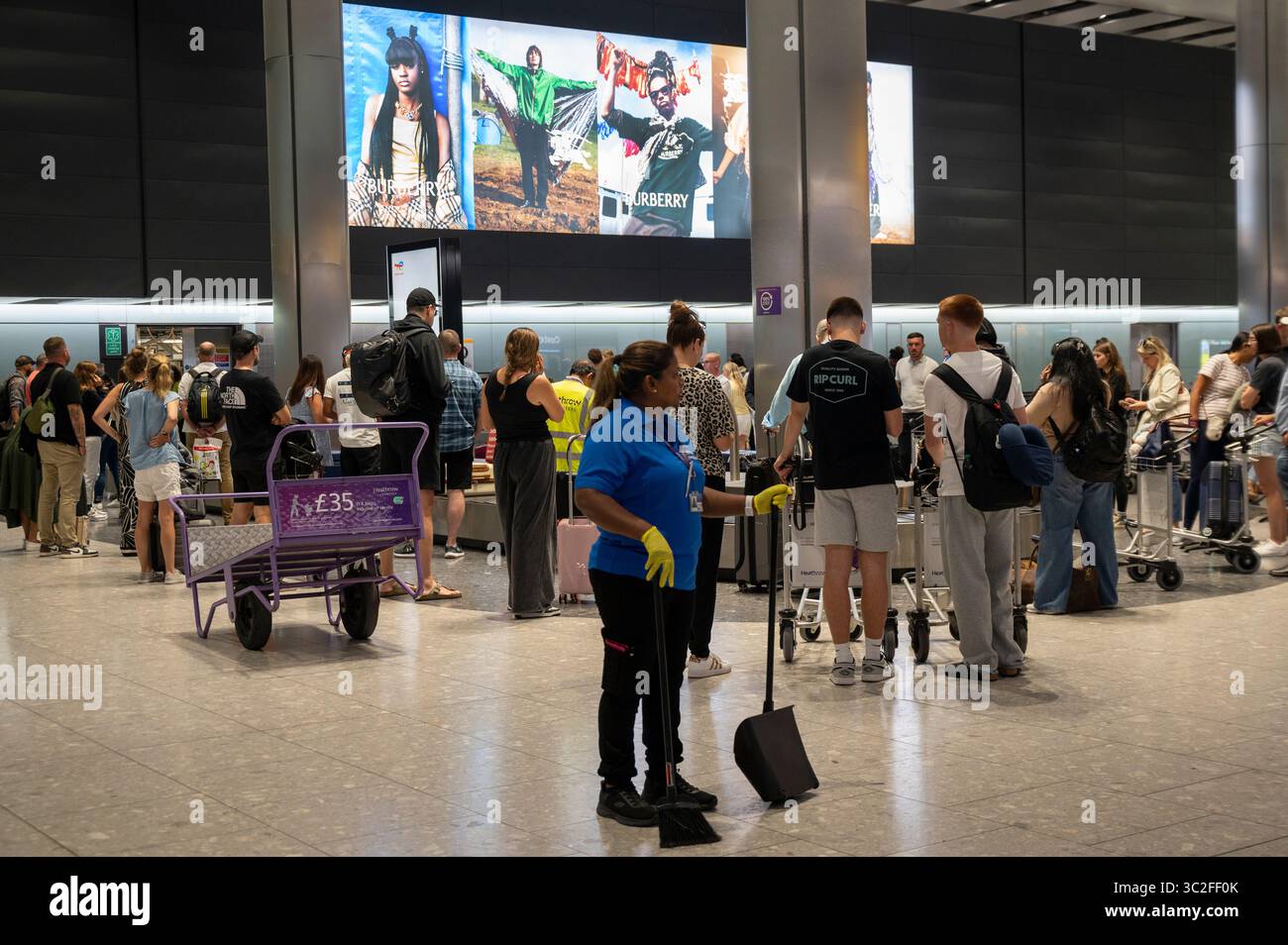 London, England. Heathrow airport. Terminal Five. Burberry advert during Glastonbury at baggage reclaim. Stock Photo
