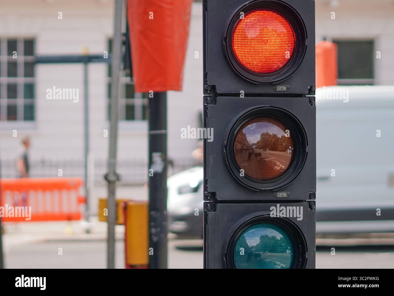 London traffic signal close to streetwork area with fences and safety barriers Stock Photo