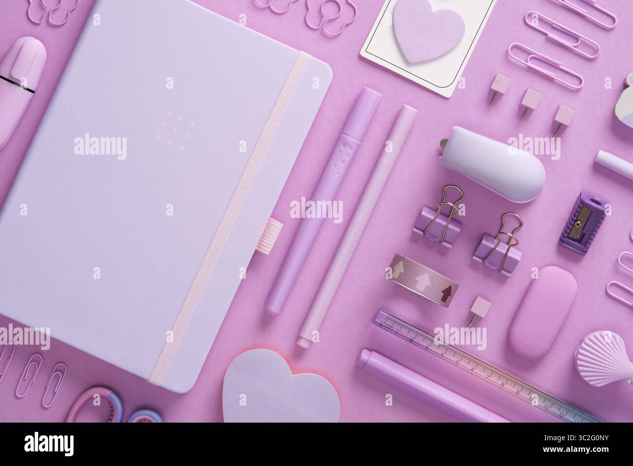 Stationery background with pastel purple supplies, notepad, paper clips, scissors, sticky notes, felt tip pens, eraser, stapler, ruler, pins Stock Photo