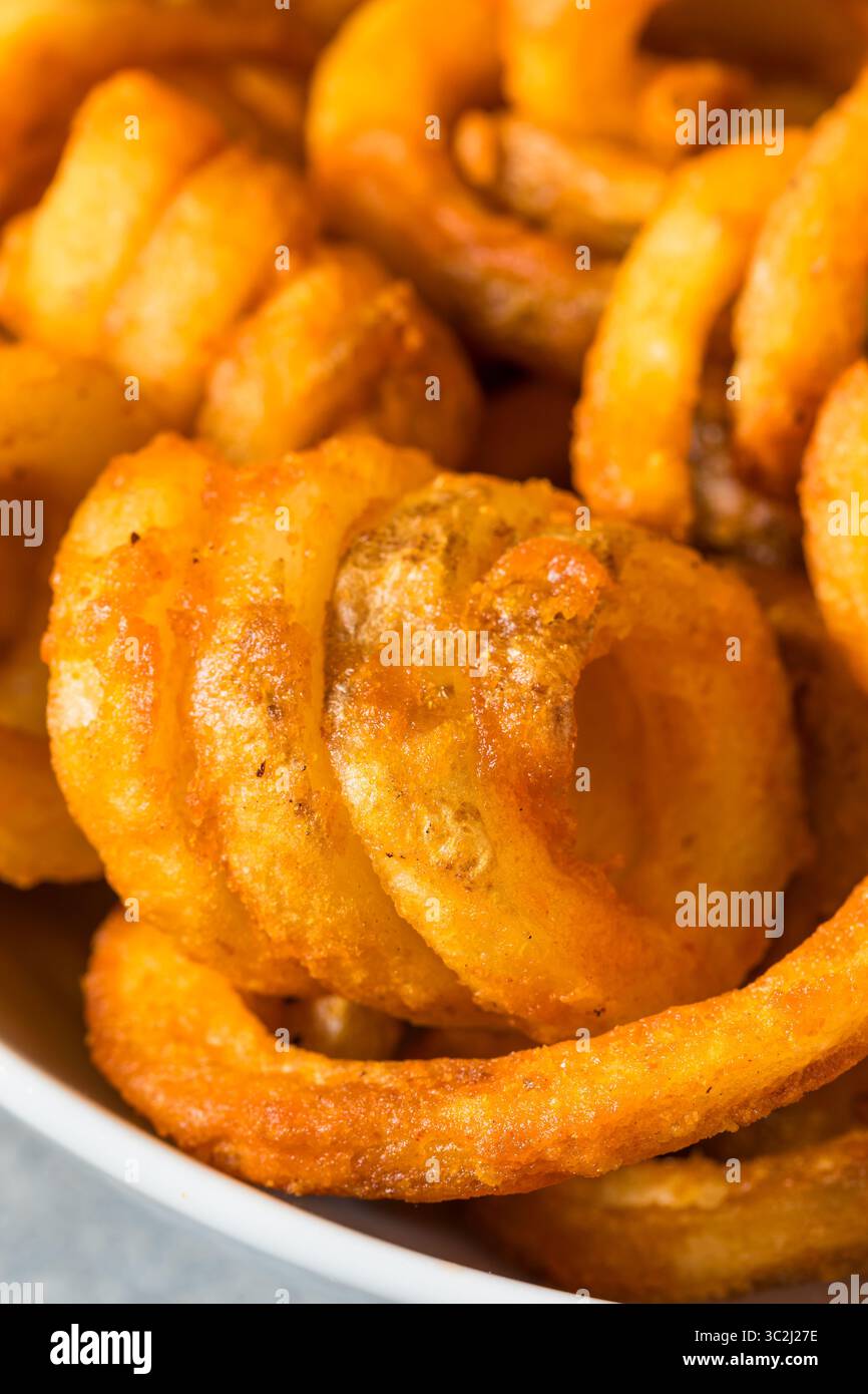 Unhealthy Seasoned Curly French Fries with Ketchup Stock Photo