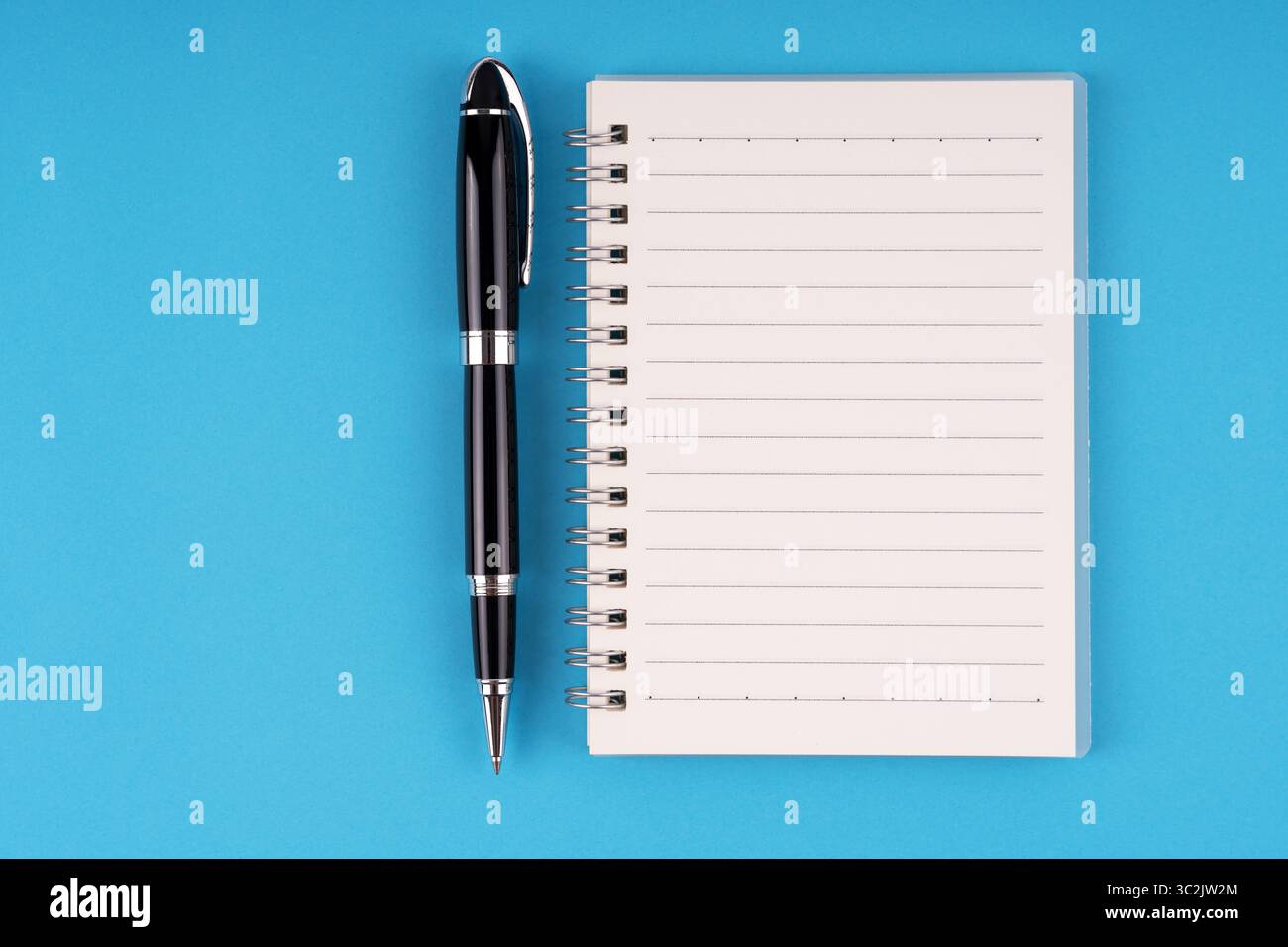 Notepad and pen on blue background Stock Photo