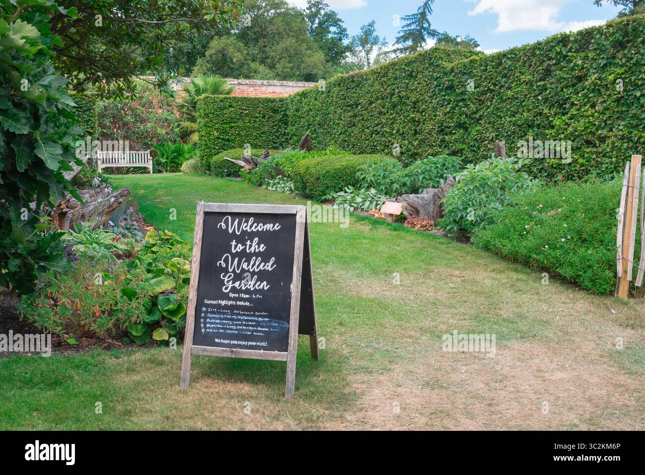 Uk gardens, view in summer of a board welcoming visitors to the attractive walled garden inside the Markshall Estate near Coggeshall, Essex, England Stock Photo