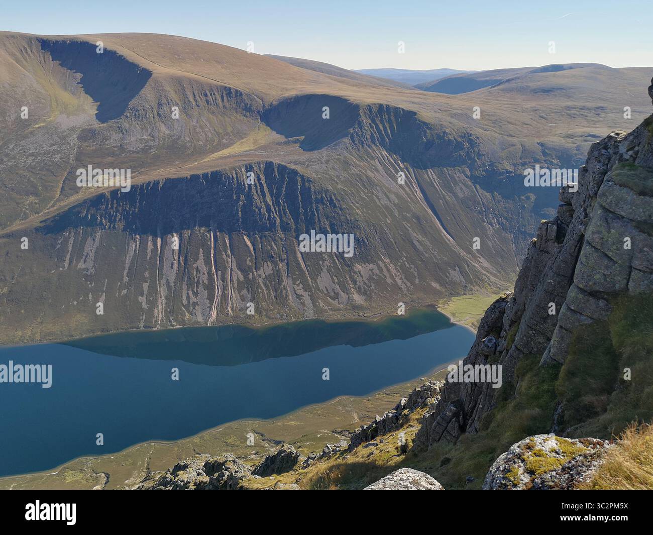 View from Sgòr Gaoith, which is a Munro in the Cairngorms Mountains. Looking over edge of crags to Glen and Loch Einich and over to Braeriach. - Smartphone Captured Stock Image