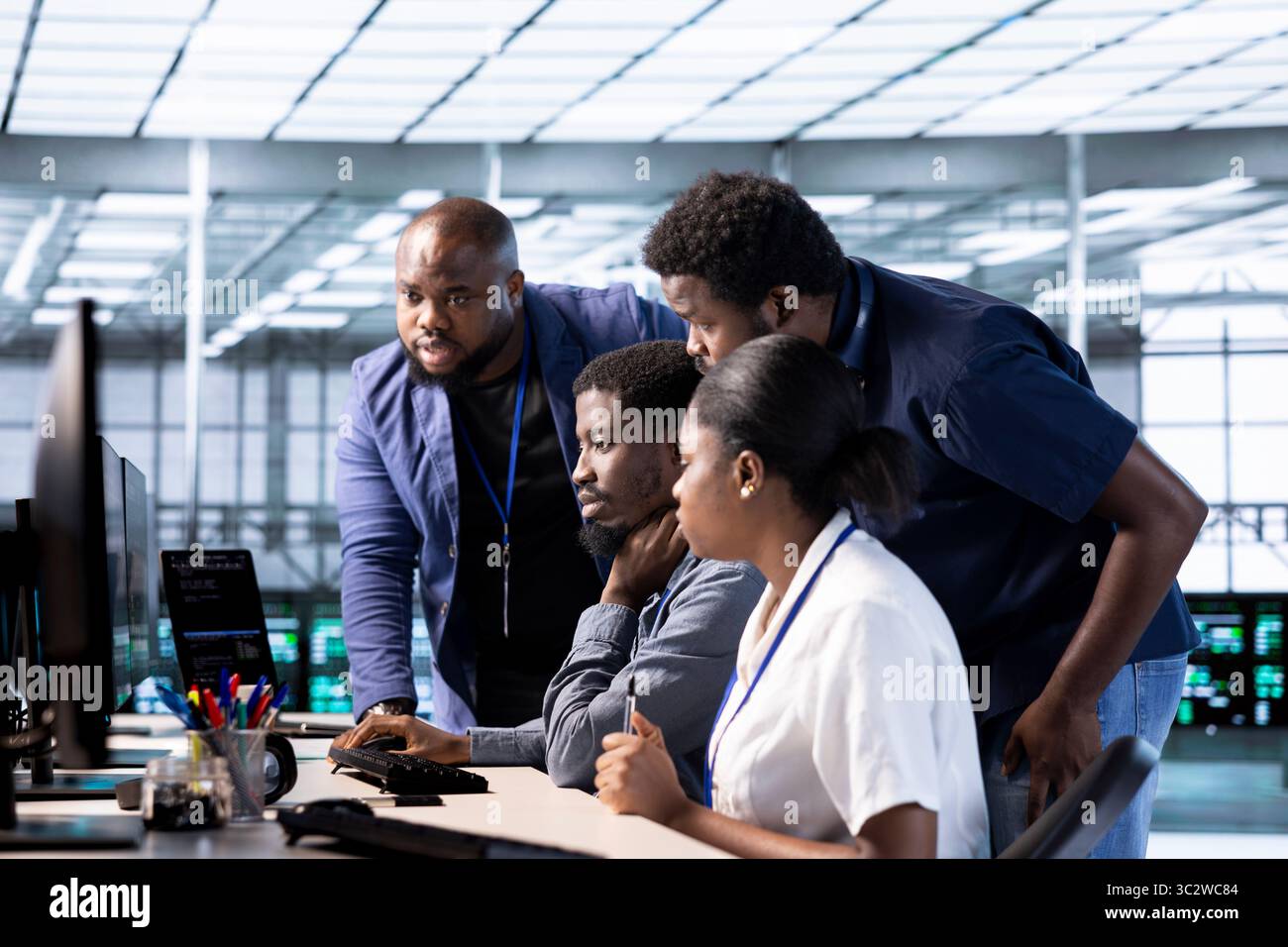 Team of data center office computer scientists using programming languages to construct algorithms and build applications. Teamworking server farm IT specialists debugging and optimizing code Stock Photo