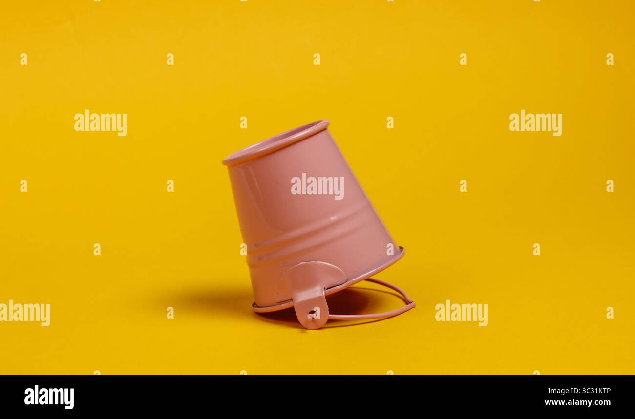 Inverted mini bucket on a yellow background close-up Stock Photo