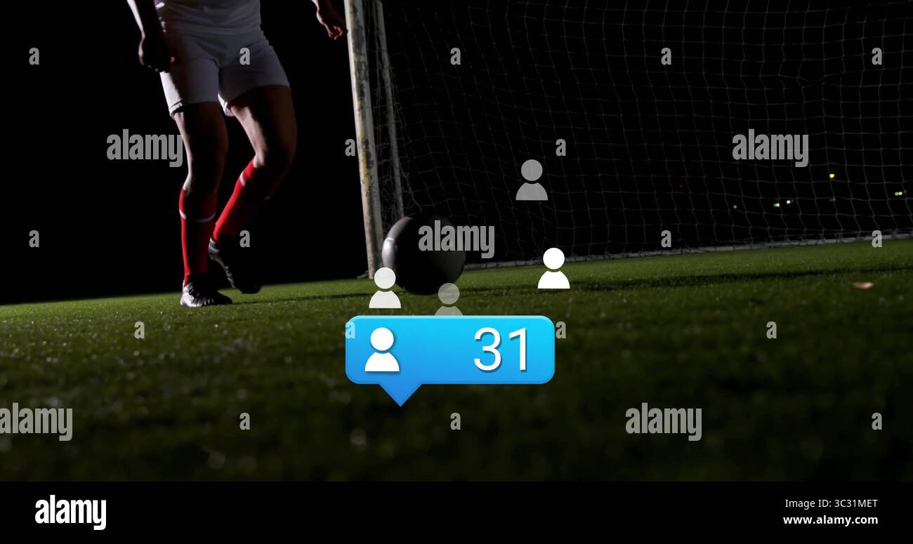 Poising soccer player legs next to ball on floodlit pitch, with net ...