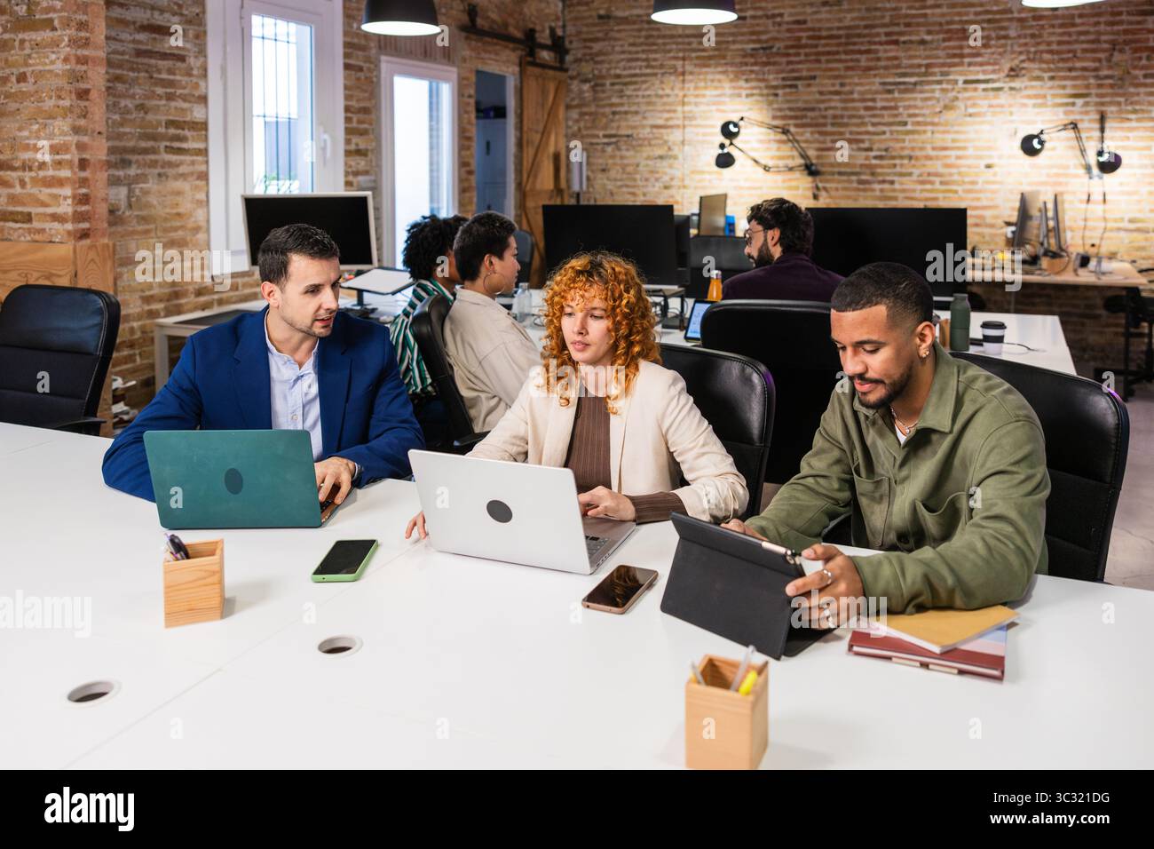 Multi ethnic team collaborating on project in modern office Stock Photo
