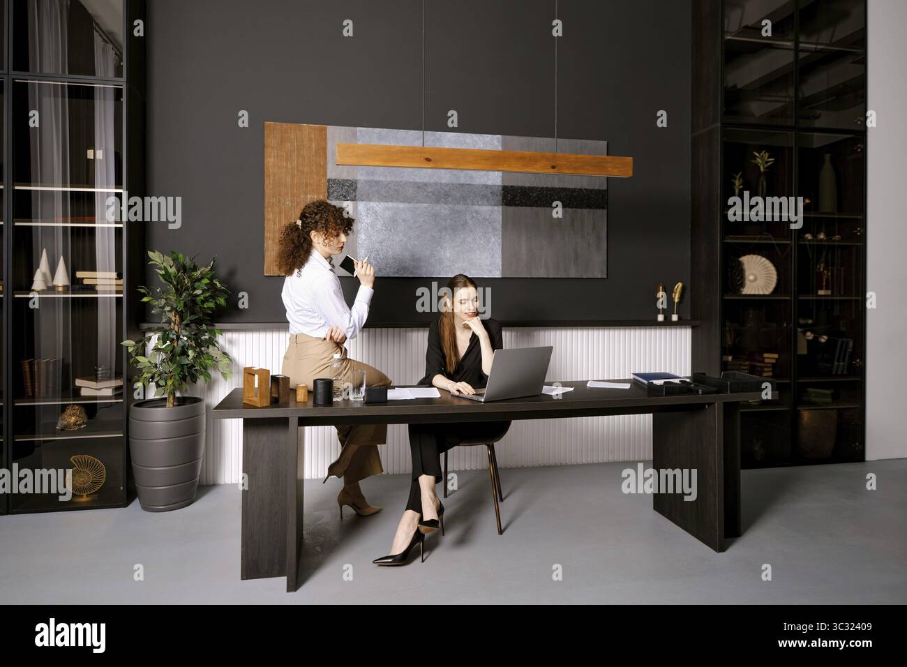 Two professionals working together in a modern office with stylish decor during the day Stock Photo
