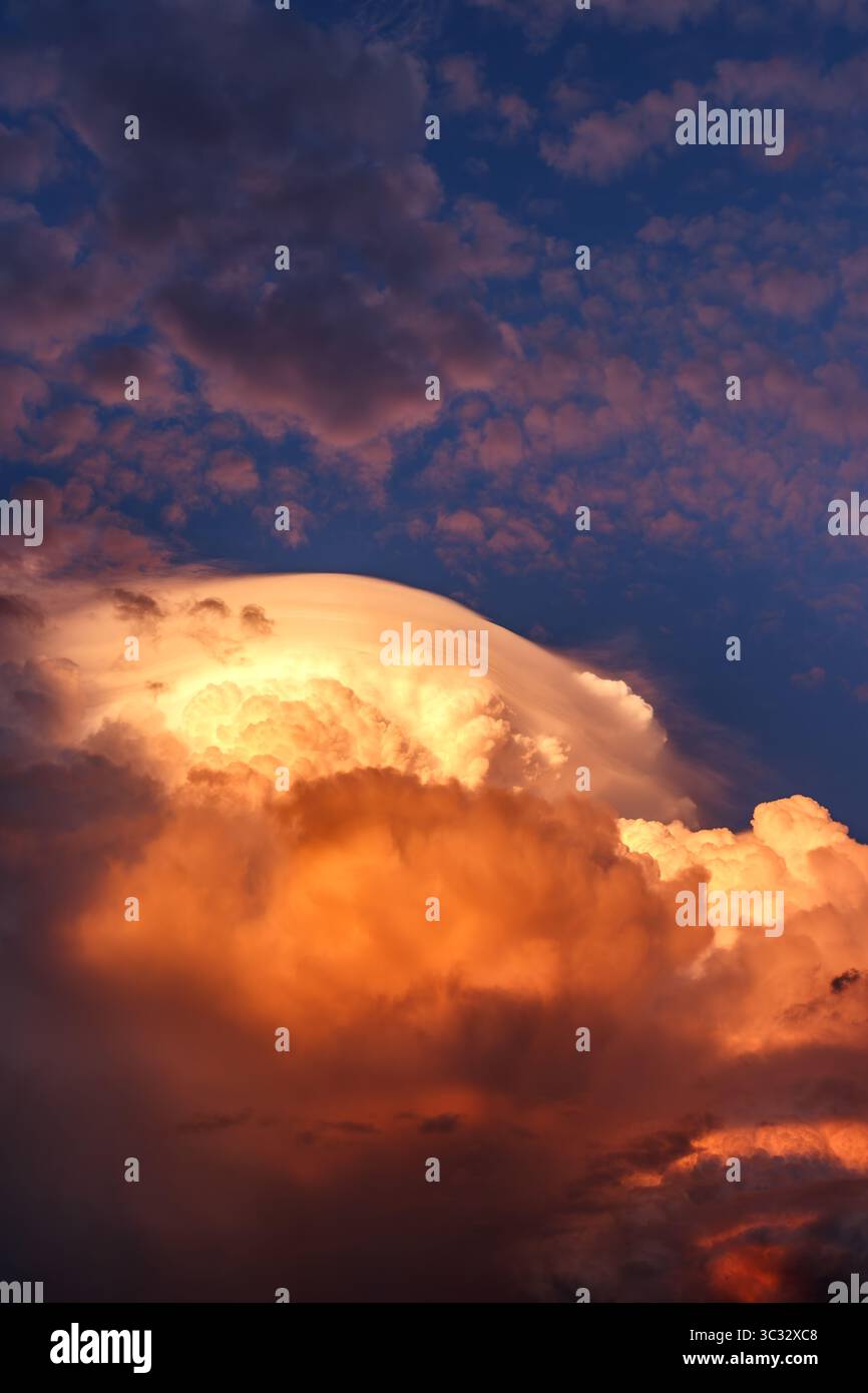 Storm clouds in evening sky, extreme weather scene with illuminated cumulonimbus formations Stock Photo