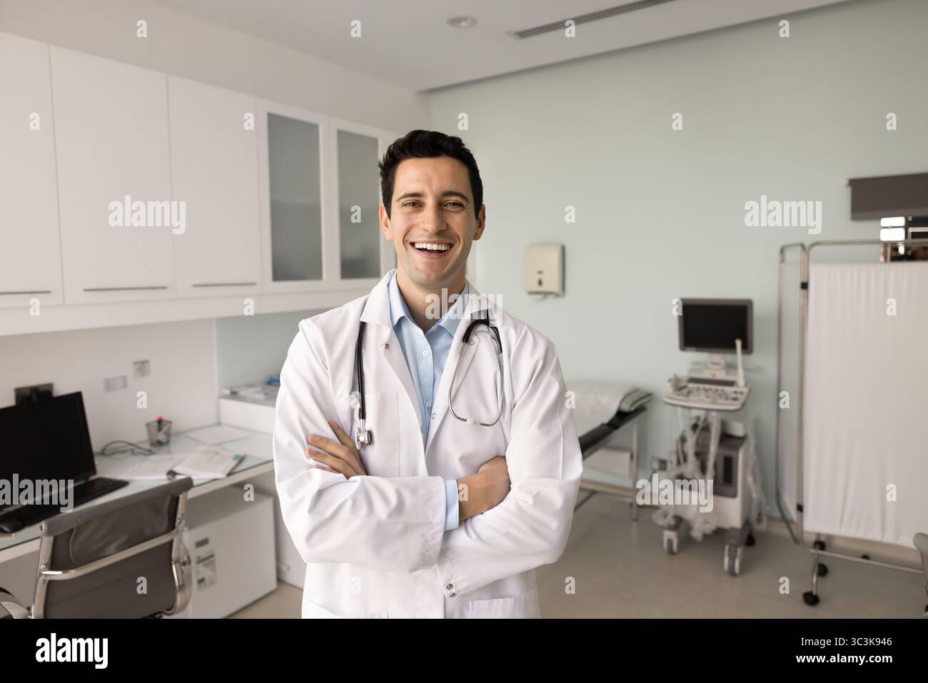 Happy successful ultrasound diagnosing medical specialist man posing in clinic Stock Photo