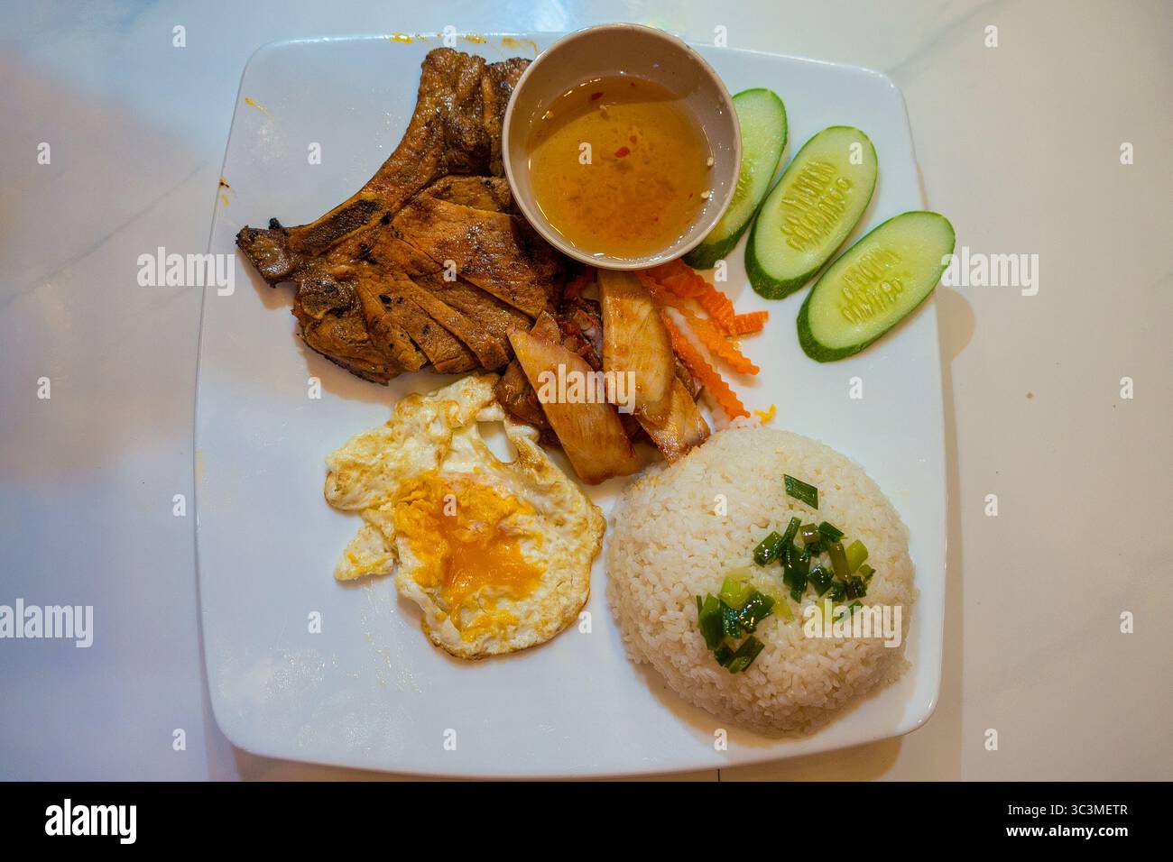 Broken rice with pork chops and eggs, a familiar dish of many ...