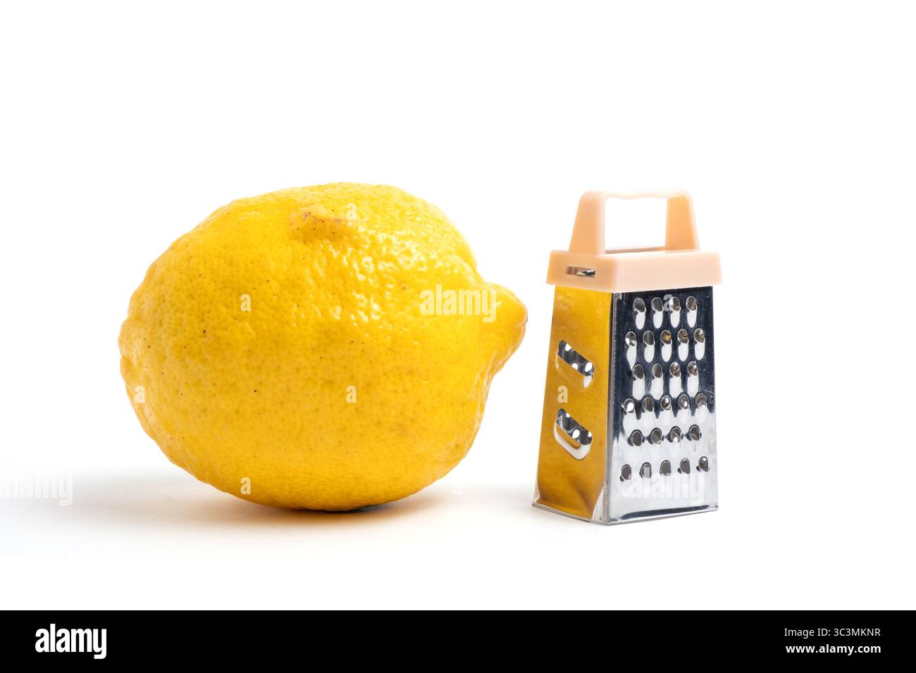 Lemon and grater on a white background. Dining hall cooking tool. Stock Photo