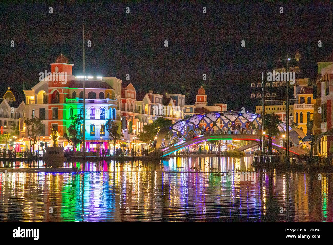 The Bridge of Light across the Lake of Love (at the Grand World Phu Quoc resort complex, Vietnam) sparkles in the magical night Stock Photo