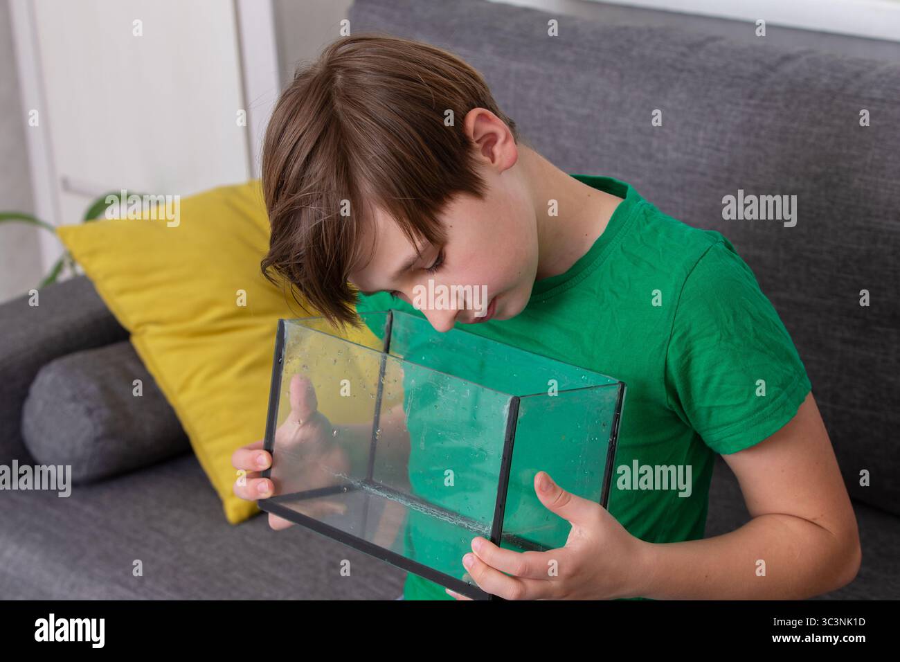Child inspects a glass container with curiosity Stock Photo - Alamy