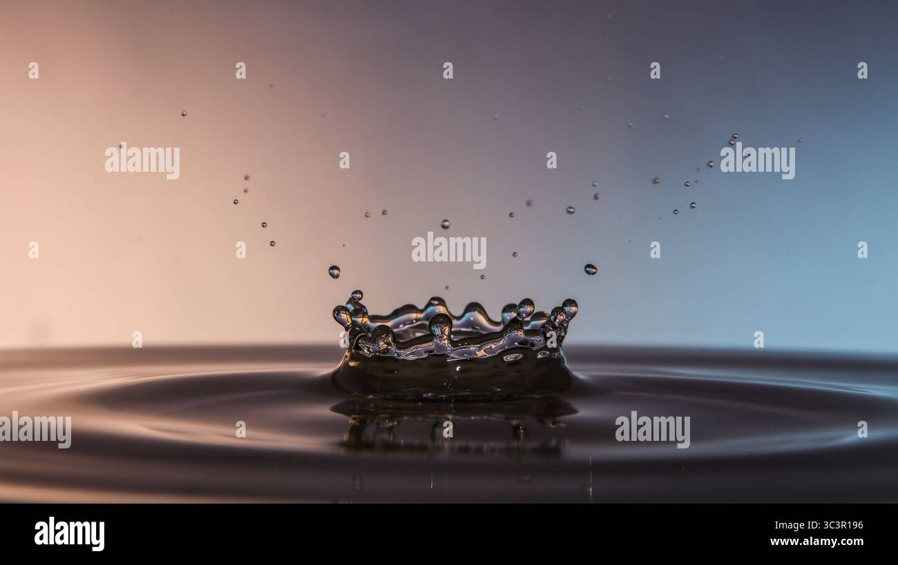 Close-up of a water droplet splash creating a crown shape on a calm ...