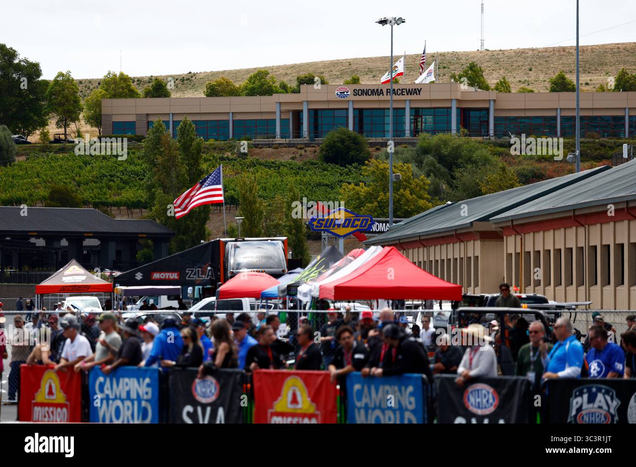SONOMA, CA - JULY 26: Fans and crew members in the infield pits watch ...