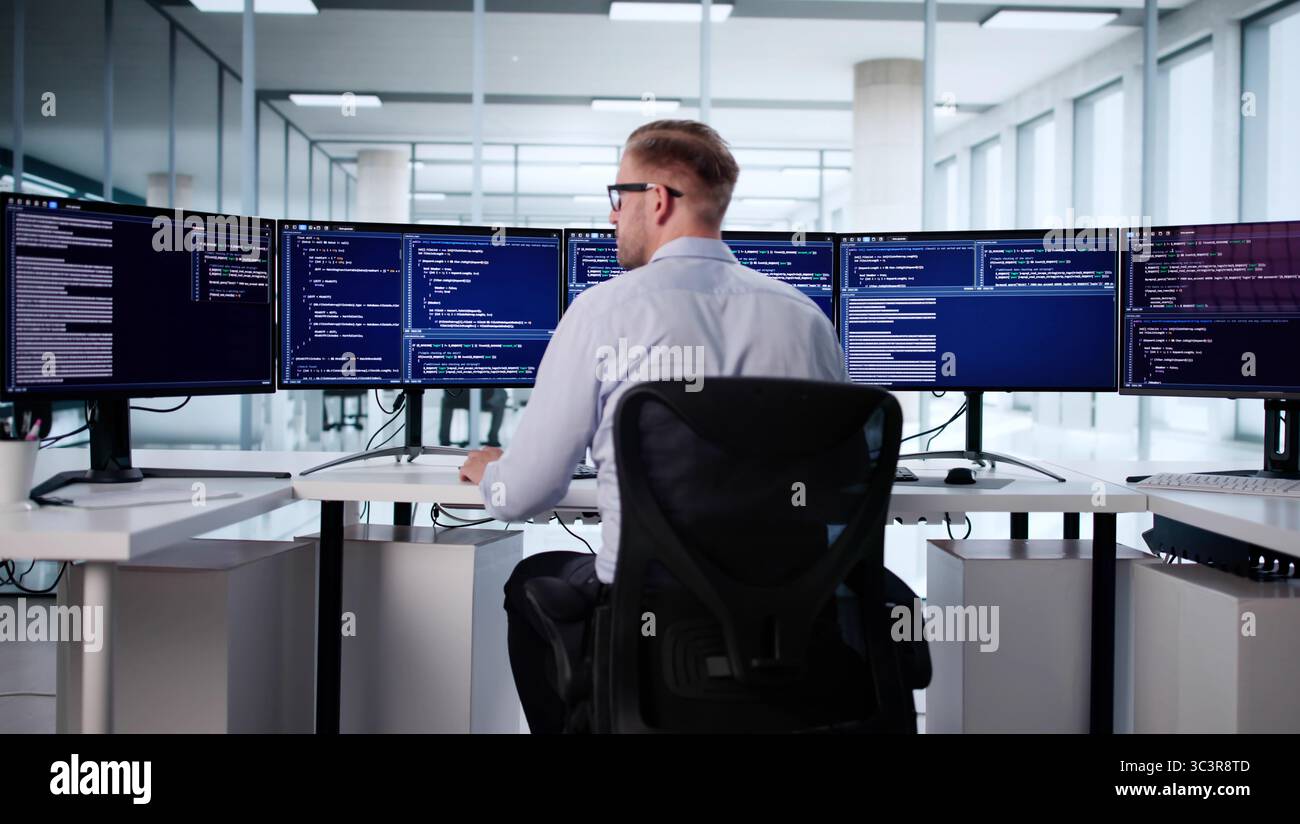 Male Software Engineer Typing Code On Office Computer Screen, Caucasian Programmer Stock Photo