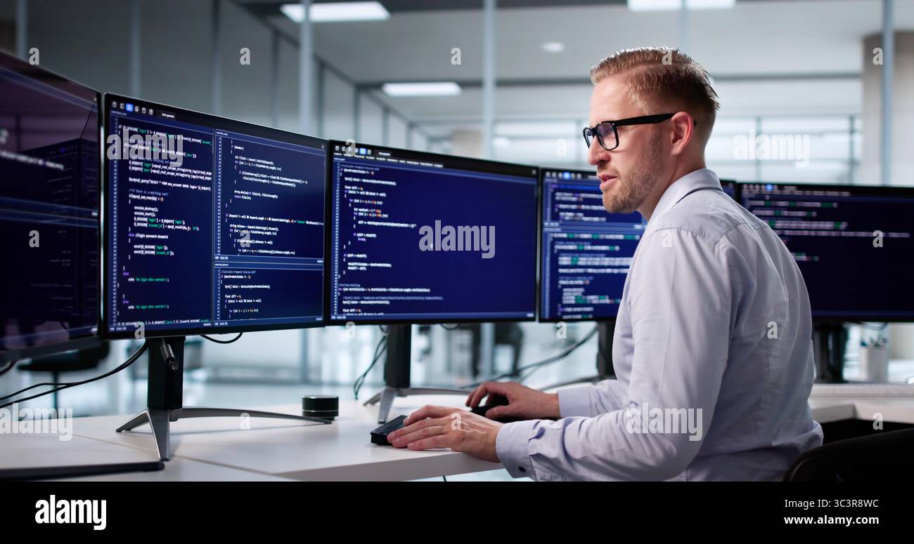 Portrait Of A Young Programmer Developing Software On His Computer Stock Photo