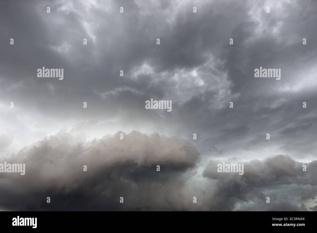 Below dark discoloured storm clouds Cloud roll above grey clouds Rain clouds heralding thunderstorms, Germany Stock Photo