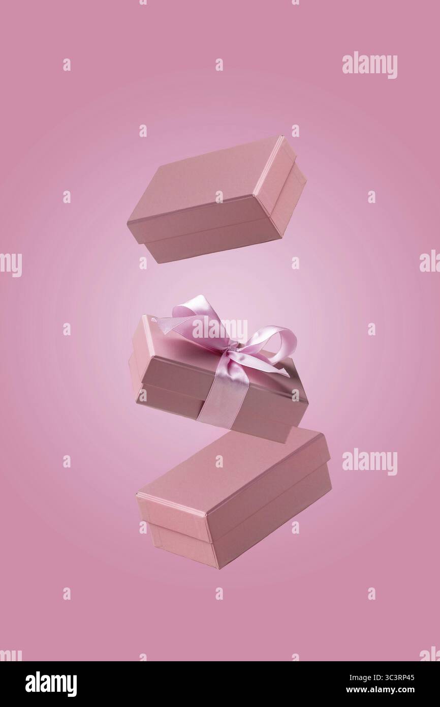 Three craft gift boxes fly on pink background Stock Photo