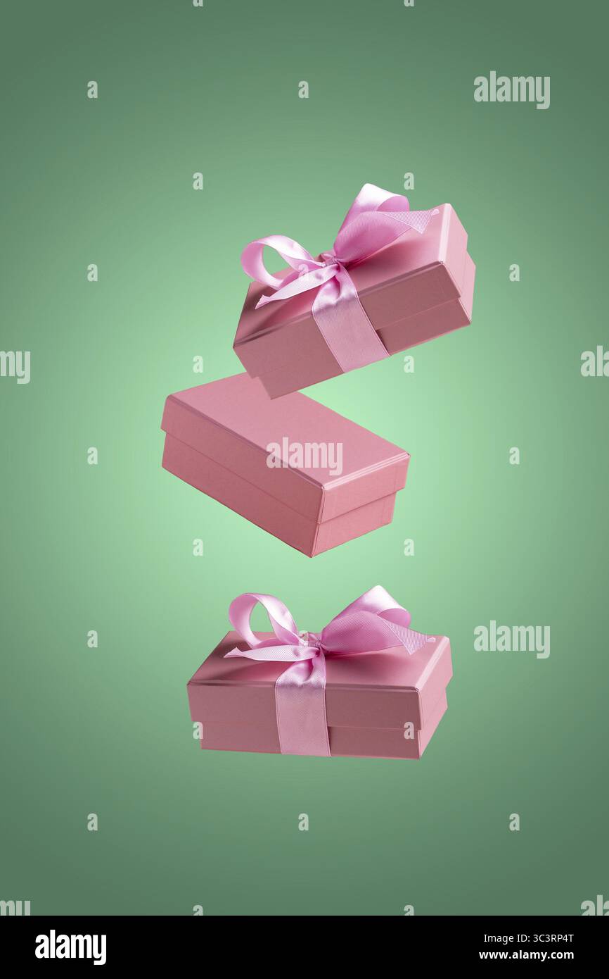 Pink gift boxes fly on a green background Stock Photo