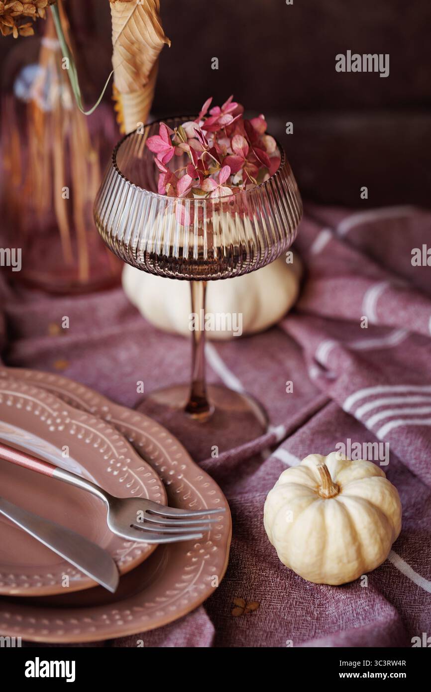 Elegant fall dining setup with rustic tableware and pumpkins Stock Photo