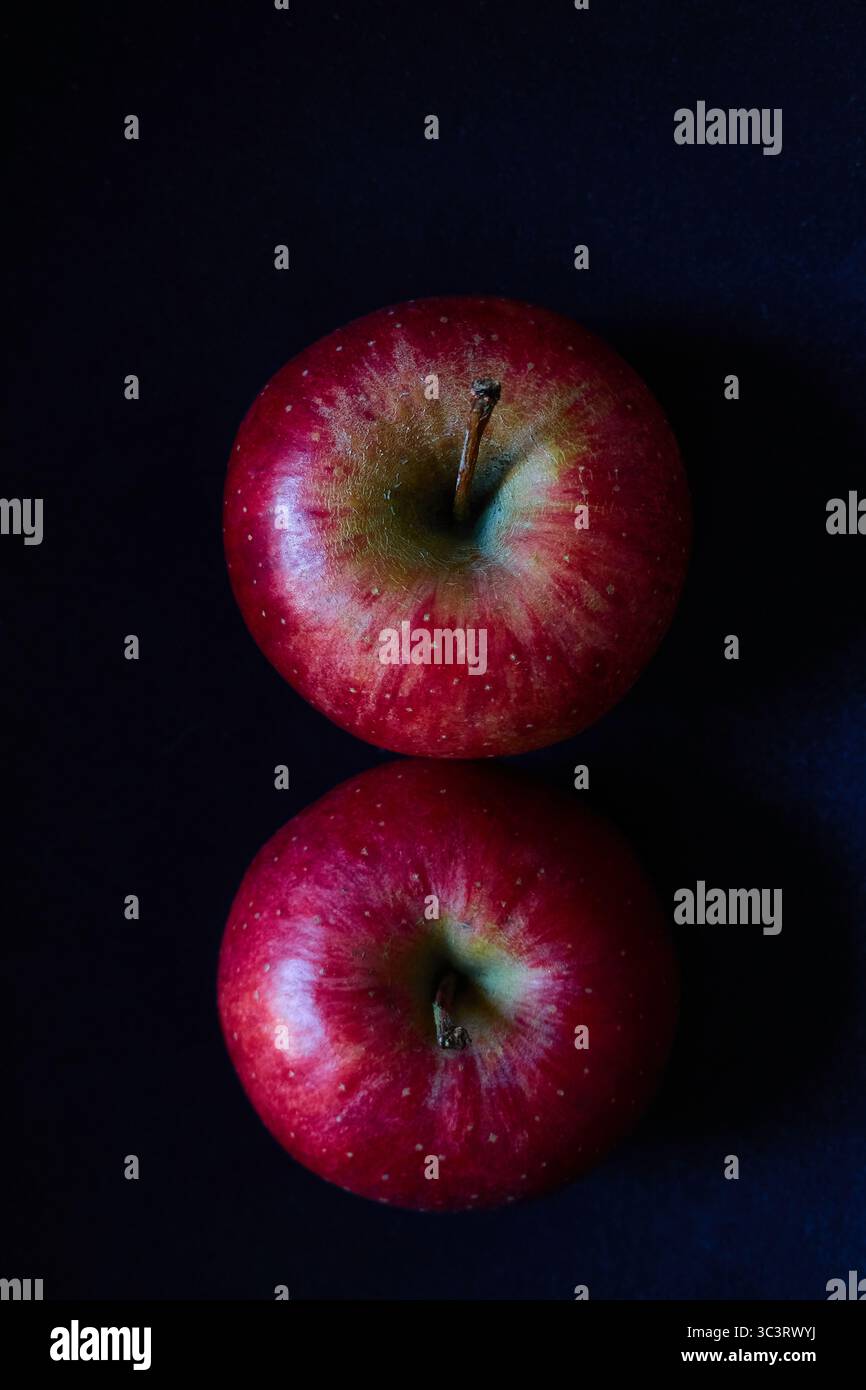 Two Vibrant Red Apples From Above on a Dark Elegant Background Stock Photo