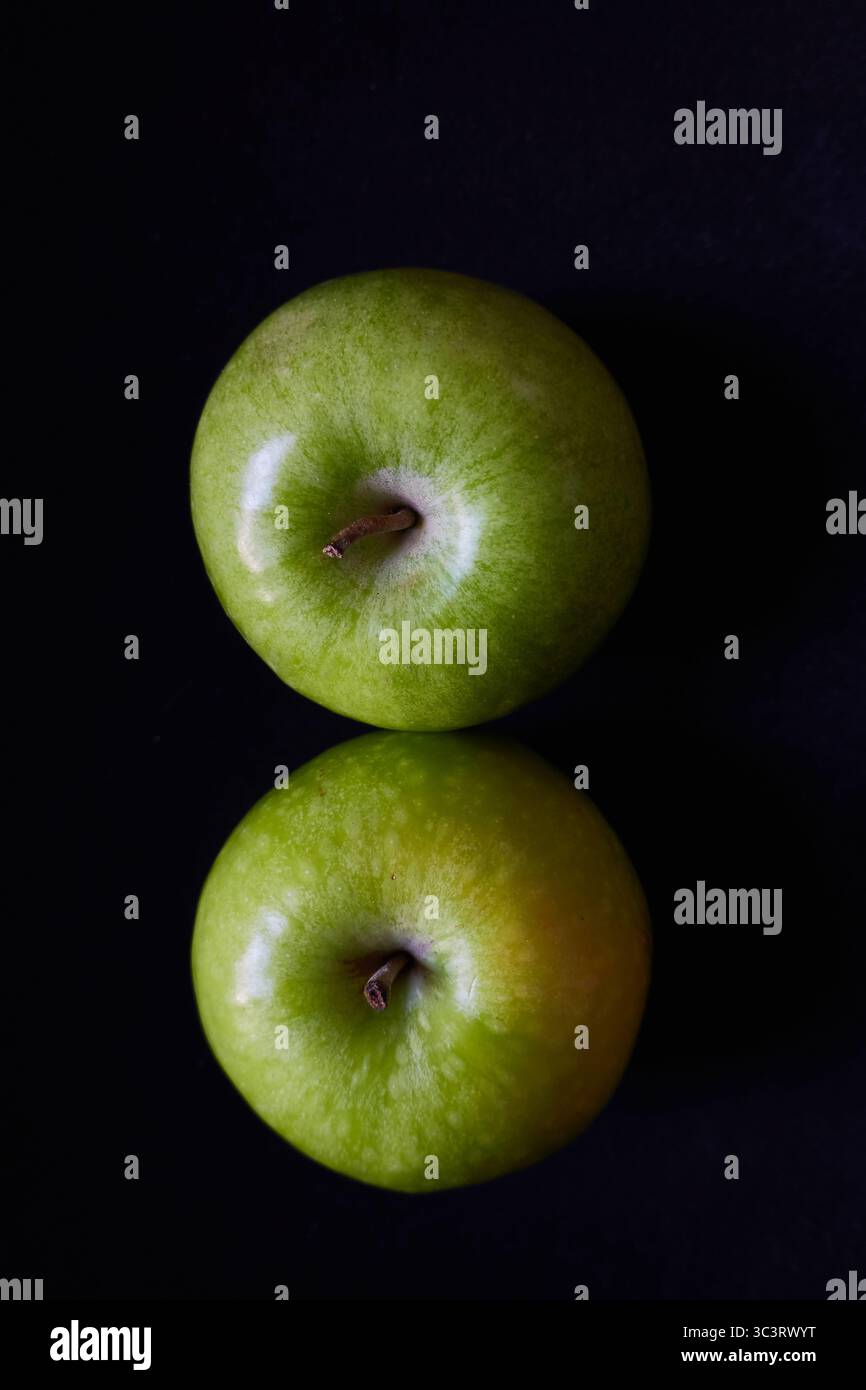 Two Green Apples from Above on a Black Background with Reflection Stock Photo