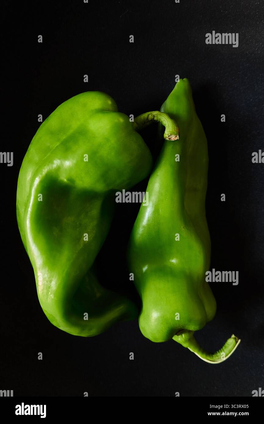 Close-Up of Two Green Poblano Peppers on a Dark Background Stock Photo